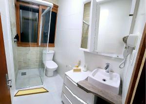 a bathroom with a sink and a shower and a toilet at LSViver Hospedagem in Caxias do Sul