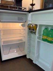 an open refrigerator filled with bottles and drinks at Jungle Bungalow at Oropel Lodge in Puerto Viejo