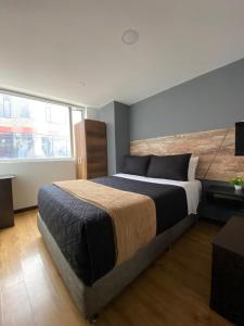 a bedroom with a large bed and a large window at Hotel Funza Real in Funza