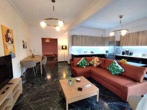 een woonkamer met een bank en een tafel bij Stylish Luxury Getaway 3BR Apartment 115m in Athene