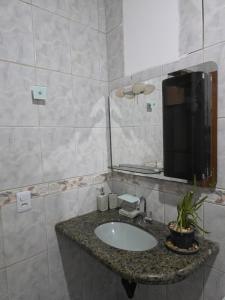 ein Badezimmer mit Waschbecken und Spiegel in der Unterkunft Jardim Primavera in Palmas