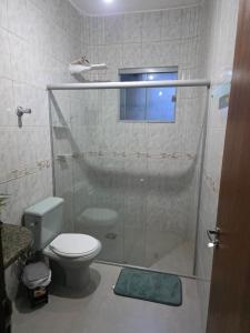 ein Badezimmer mit Dusche, Toilette und Fenster in der Unterkunft Jardim Primavera in Palmas + 7 Fotos