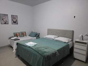 ein Schlafzimmer mit 2 Betten und eine Kommode mit einem Bett sidx sidx sidx sidx sidx in der Unterkunft Jardim Primavera in Palmas