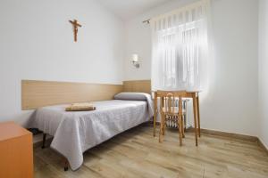 a small bedroom with a bed and a chair at Alojamiento cristo rey in Pozuelo de Alarcón