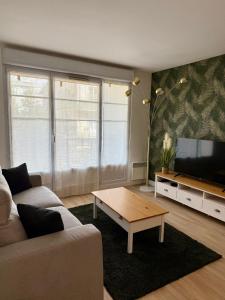 ein Wohnzimmer mit Couch und Flachbildfernseher in der Unterkunft Spacieux 70m2 - 2 chambres - 5 min Disneyland in Montévrain