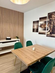 ein Esszimmer mit einem Holztisch und grünen Stühlen in der Unterkunft Spacieux 70m2 - 2 chambres - 5 min Disneyland in Montévrain
