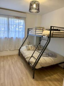 ein Schlafzimmer mit zwei Etagenbetten und einem Fenster in der Unterkunft Spacieux 70m2 - 2 chambres - 5 min Disneyland in Montévrain
