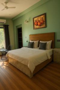 a bedroom with a large bed with fruit on the wall at Niladri farms in Bhundsi