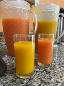 two glasses of orange juice sitting on a counter at Pousada Bela Vista do Ismail - Lapinha da Serra in Santana do Riacho +22 photos
