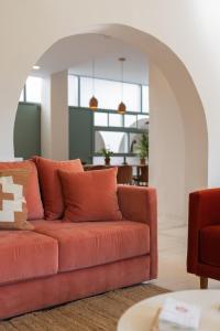 an orange couch in a living room with an archway at Outsite Oaxaca City - Work, Connect, Explore in Oaxaca City