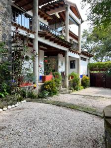 ein Haus mit einem Balkon und einer Kieseinfahrt in der Unterkunft El Encino in Tepoztlán