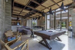 ein Wohnzimmer mit Billardtisch und Stühlen in der Unterkunft Brand new 4BR Villa at Calablanca in Pendales