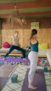 Dos mujeres están haciendo yoga en una habitación. en caban surf Tamraght, en Tamraght Ouzdar