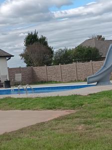 a swimming pool with a slide in a yard at Ben Cabin in Natchitoches