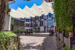 a courtyard with tables and chairs under a white canopy at Hotel Terra by Refugio Ecológico in Arequipa