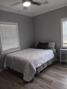 a bedroom with a bed and two windows at Ben Cabin in Natchitoches +19 photos