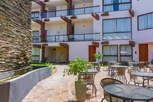 an outdoor patio with tables and chairs in front of a building at Hotel Terra by Refugio Ecológico in Arequipa