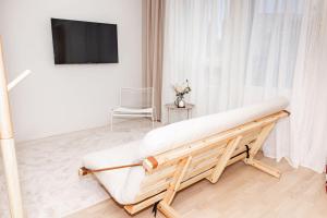 a white room with a couch and a tv at Aurora Suite, Rovaniemi city center in Rovaniemi