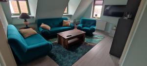 a living room with two blue chairs and a table at De Lütte Nest in Waren