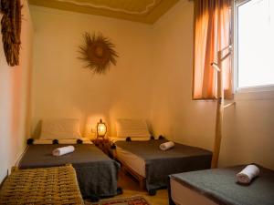 a room with two beds and a window at caban surf Tamraght in Tamraght Ouzdar