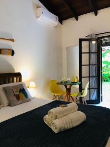 une chambre avec un lit et une table avec des chaises dans l'établissement Canto do Una- hospedagem, à Barra do Una