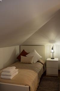 a bed with pillows and a lamp on top of it at Horizonte Azul in Ponta do Sol