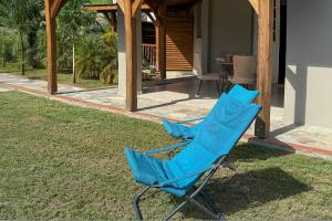 a blue chair sitting on the grass in front of a house at Perle d'Arlet in Les Anses-dʼArlets
