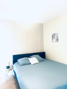 a bedroom with a blue bed and a table at cosy studio dans une maison d'hôte in Bourg-en-Bresse