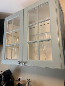 a kitchen cabinet with wine glasses in it at cosy studio dans une maison d'hôte in Bourg-en-Bresse