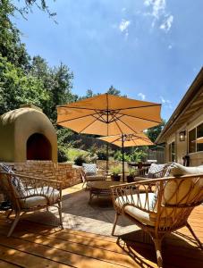 Un patio con mesas y sillas y una sombrilla. en Art Deco Gem-King Suite-Hot Tub-Outdoor Fire Place, en Round Rock