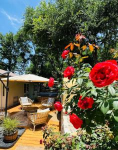 un jardín con rosas rojas en un patio en Art Deco Gem-King Suite-Hot Tub-Outdoor Fire Place, en Round Rock