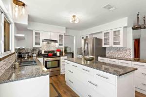 Una cocina con gabinetes blancos y encimeras de granito. en Art Deco Gem-King Suite-Hot Tub-Outdoor Fire Place, en Round Rock 37 fotos más