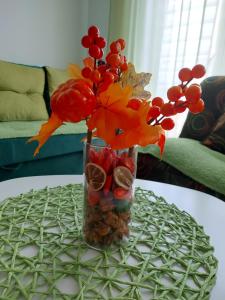 a vase with flowers and fruit on a table at stancicmilena in Požarevac