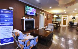 a living room with a table and a tv on the wall at Best Western Point South in Yemassee