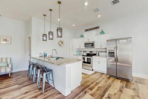 een keuken met witte kasten en roestvrijstalen apparaten bij Breezy Cottage in Rockport