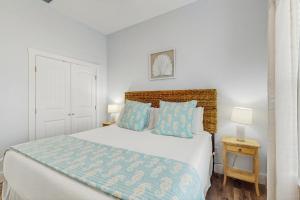 een slaapkamer met een groot bed met blauwe kussens bij Breezy Cottage in Rockport +21 foto's