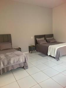 a bedroom with two beds and a tiled floor at The Riverside in Novo Acordo