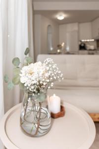 a vase with flowers and a candle on a table at Aurora Suite, Rovaniemi city center in Rovaniemi