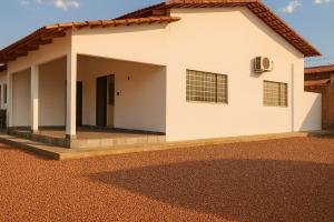 a white house with a gravel driveway at The Riverside in Novo Acordo