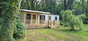 a wooden cabin in a field with a tree at La vie slow 336 in Monterblanc