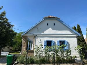 a white house with a fence in front of it at Kökény Kunyhó in Kisszékely +3 photos