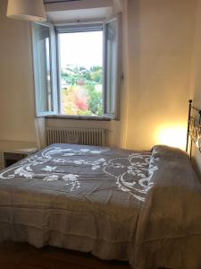 a bed in a room with a window at Affittacamere L'albero della vita in Sinalunga