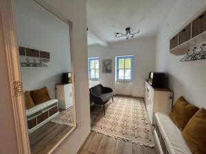 a room with a mirror and a couch and a chair at Kökény Kunyhó in Kisszékely