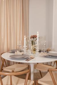 a white table with candles and plates and chairs at Aurora Suite, Rovaniemi city center in Rovaniemi +27 photos