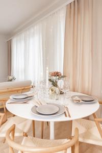 a white dining room table with chairs and a white curtain at Aurora Suite, Rovaniemi city center in Rovaniemi
