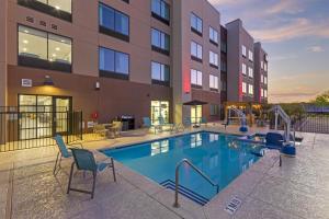 フェニックスにあるBest Western Plus Executive Residency Phoenix North Happy Valleyの椅子付きプール、建物の前の滑り台