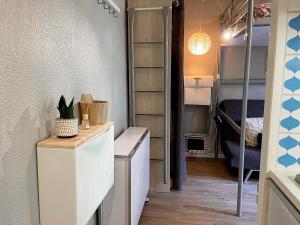 a room with a small refrigerator and a bedroom at Studio cosy proche départ station de ski in Porté-Puymorens