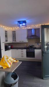 ブラスカートにあるBeach Houseの白いキャビネットと青い照明付きのキッチン