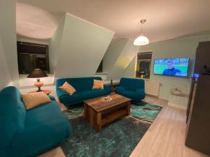 a living room with two blue couches and a tv at De Lütte Nest in Waren