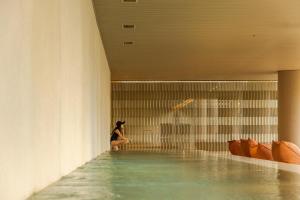 a woman sitting in the water in a swimming pool at Pulso Hotel Faria Lima in São Paulo